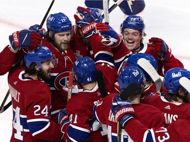 Montreal Canadiens left wing Phillip Danault (24), right wing Josh Anderson (17) and right wing Cole Caufield (22) celebrate with their teammates after Anderson scored the winning goal in overtime against the Tampa Bay Lightning  during Game 4 of the Stanley Cup final in Montreal on Monday, July 5, 2021.