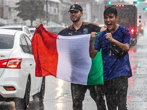Rain did not dampen Italian fans Joseph Lombardi and Luca Fabrizio, right, after Italy defeated Spain in a penalty shootout at the Euro 2020 tournament on July 6, 2021. The two celebrated outside Café Milano in Little Italy.