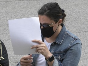 Stéphanie Viau tries to hide from cameras as she arrives at the Gouin courthouse on Tuesday July 6, 2021. Viau testified in the murder trial of her sister Marie-Josée Viau and Guy Dion.