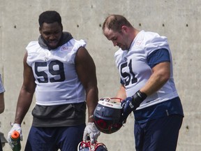 Guards Kristian Matte (right) and Junior Luke of the Montreal Alouettes talk at the team's camp Sunday, July 11, 2021 at the team's practice field near the Olympic Stadium in Montreal.
