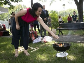 Mayor Valérie Plante, sprinkles tobacco on ceremonial fire in front of building that is being converted into a transition house for Indigenous women.