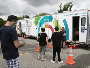 People line up for their shot at a mobile vaccination clinic in Rivière-des-Prairies in July.