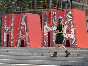 A worker walks past the newly installed display for the Just For Laughs festival at Place des Festival on July 14, 2021.