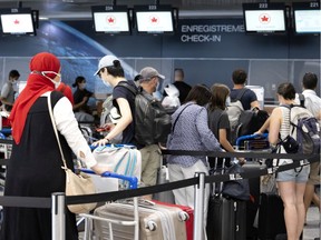 Travellers line up to check in at the Air Canada counter in Trudeau airport in Montreal on Monday, July 19, 2021.