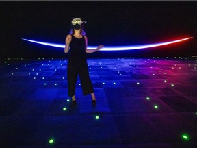 A reporter wears virtual reality headset while getting an advance tour of The Infinite, a virtual reality experience aboard the International Space Station, at Arsenal in Montreal, Tuesday July 20, 2021.