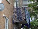 Blankets and towels drape the balcony of an apartment where a woman was slain Monday in a building on Birnam St. in the Parc-Extension district on Tuesday.
