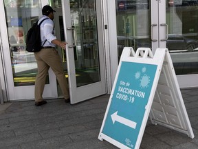 A man arrives at the Covid-19 vaccination centre in the Palais des congres, in Montreal on Wednesday, July 21, 2021. (Allen McInnis / MONTREAL GAZETTE) ORG XMIT: 66439