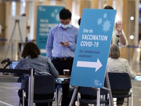 MONTREAL, QUE.: July 21, 2021 -- People register for the Covid-19 vaccination at the centre in the Palais des congres, in Montreal on Wednesday, July 21, 2021. (Allen McInnis / MONTREAL GAZETTE) ORG XMIT: 66439