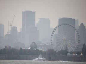 A small ferry arrives in the Old Port of Montreal as smog clouds the skyline on July 26, 2021. The smog, caused by forest fires in northwestern Ontario, prompted a warning from Environment Canada.