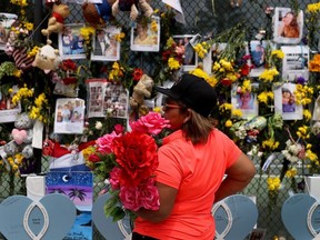 Lucia Gutierrez visits the memorial that has pictures of some of the missing from the partially collapsed 12-story Champlain Towers South condo building on July 7, 2021 in Surfside, Florida.