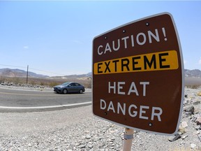 A warning sign alerts visitors to heat dangers on July 11, 2021 in Death Valley National Park, Calif.