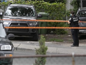 A Montreal police officer at the scene of the 12th murder of 2021, near the corner of Paris and Monselet Sts. in Montreal North.