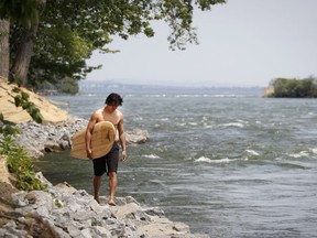 Xavier Alcivar walks along the shore of the St. Lawrence River wave in Montreal on Tuesday, June 8, 2021. How long until we’re slathering on SPF 8000 for a day outdoors?