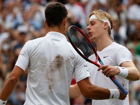 Serbia's Novak Djokovic, left, greets Canada's Denis Shapovalov after winning their men's singles semi-final match on the 11th day of the 2021 Wimbledon Championships at The All England Tennis Club in Wimbledon, southwest London, on July 9, 2021.