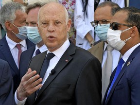 Tunisian President Kais Saied speaks with reporters at the headquarters of the central pharmacy in the capital Tunis on July 23, 2021, during a ceremony to receive French aid to combat COVID-19 in the presence of France's Secretary of State for Tourism (unseen).