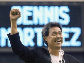Former Montreal Expos ace Dennis Martinez raises his fist during a ceremony for the Montreal Expos Hall of Fame in Montreal on July 24, 2004.