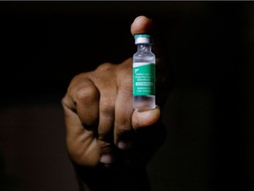 A man displays a vial AstraZeneca's COVISHIELD vaccine.