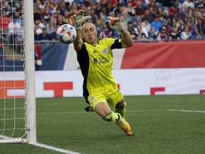 New England Revolution goalkeeper Brad Knighton (18) makes save on a shot from a CF Montréal player during the first half of an MLS soccer match, Sunday, July 25, 2021, in Foxborough, Mass.