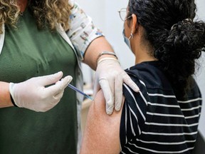A teenager receives a dose of the Pfizer/BioNTech Covid-19 vaccine at the Clalit Healthcare Services in the Israeli city of Holon near Tel Aviv on June 21, 2021, as Israel begins coronavirus vaccination campaign for 12 to 15-year-olds.