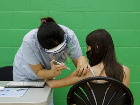 A teen receives a dose of the Pfizer-BioNTech COVID-19 vaccine at a clinic in Toronto.