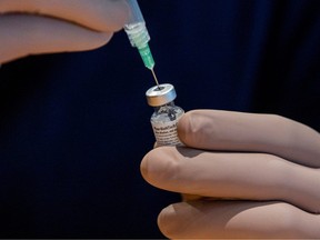 A health care worker prepares a dose of the Pfizer/BioNTech COVID-19 vaccine.