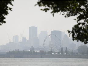 A haze- and smog-filled skyline of Montreal as seen from Ile-Ste-Hélène on July 26, 2021.