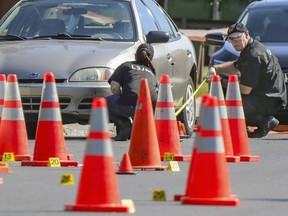 Crime scene technicians use a tape measure while gathering evidence at the scene of a shooting in Montreal's Riviere-des-Prairies district Tuesday August 3, 2021 that occurred Monday evening leaving three people dead and two others injured.