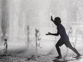 A child playing in the water fountains at Place des Festivals in Montreal's Quartier des spectacles.