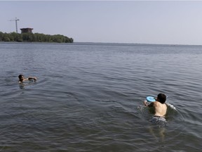 Elsa and Esteban play frisbee along the shore of the St. Lawrence as Montrealers try to escape the 32 degree heat in Montreal, on Tuesday, August 10, 2021.