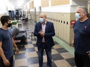 EMSB Chair Joe Ortona, centre, speaks to McGill premed student and Royal Vale School summer employee Devon Haseltine, left and  head caretaker Kostas Maniatias about the school opening preparations in Montreal, on Wednesday, August 11, 2021.