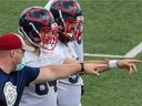 Offensive line coach Luc Brodeur-Jourdain and center Sean Jamieson point out the positioning during Alouettes' practice at Olympic Park on Wednesday.