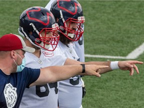 Offensive-line coach Luc Brodeur-Jourdain and centreSean Jamieson point out positioning during Alouettes practice at Olympic Park on Wednesday.