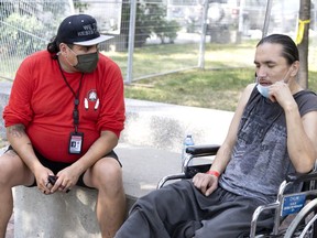 Outreach worker Wayne Robinson speaks to a homeless man named Jersey to make sure he has made medical arrangements for an ankle injury.