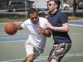 Mouvement Montréal mayoralty candidate Balarama Holness, left, makes his way past Mouvement Montréal St-Jacques riding candidate Shane Thompson during a local hoop tournament in Little Burgundy on Saturday, August 21, 2021. Holness would like to bring an NBA team to Montreal.