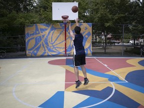 Mathieu Licheron enjoys a few throws at the newly designed surface of the Francorama, a basketball court in Little Italy, on Sunday August 22, 2021. The new surface was designed by illustrator Franco Égalité and his part of the 2021 Mural exhibit.
