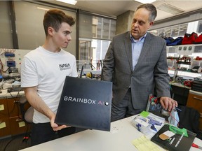 Brainbox AI chief technology officer and co-founder Jean-Simon Venne, right, talks with technician Simone Polidori at their office in Montreal on Friday, Aug. 20, 2021.