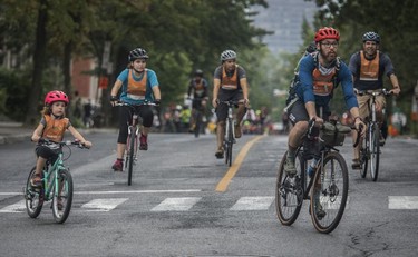 Mérédith Bernier (left), with her father Pierre-Luc (right) ride on rue Cherrier during the Tour de l'Île in Montreal on Aug. 29, 2021.