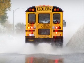 A school bus kicks up water spray in Montreal.
