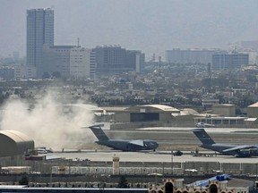 U.S. soldiers stand on the tarmac as an U.S. Air Force aircraft prepares for take off from the airport in Kabul on Aug. 30, 2021. Rockets were fired at Kabul's airport where U.S. troops were racing to complete their withdrawal from Afghanistan and take out allies under the threat of Islamic State group attacks.
