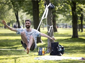 Robin Renault steadies himself as he prepares to stand while slack lining in Montreal on July 28, 2021