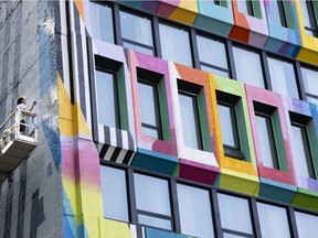 Mural artist Mad Rats works on a new colourful mural, Dazzle My Heart, by Michelle Hoogveld painted on the facade of the St. Germain Hotel.