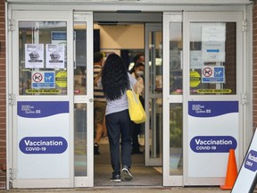 A woman enters the COVID-19 vaccination clinic at the Bob Birnie Arena in Pointe Claire on Thursday, Aug. 19, 2021.