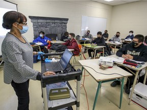 A masked teacher speaks to a class at John F. Kennedy High School in Montreal Tuesday November 10, 2020.