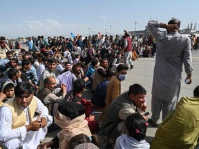 People fleeing the Taliban wait to leave the Kabul airport in Afghanistan on Aug. 16, 2021.