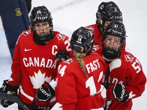 Canada's Marie-Philip Poulin, left, celebrates her goal with teammates during second period IIHF Women's World Championship hockey action against Germany in Calgary, Saturday, Aug. 28, 2021.