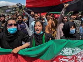 People carry the national flag at a protest held on Afghan Independence Day in Kabul, Afghanistan Aug. 19, 2021.