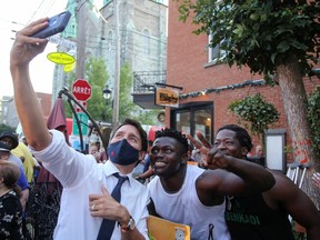 Federal Liberal Leader Justin Trudeau takes a selfie with supporters during a campaign stop in his Papineau riding in Montreal on Sunday, Aug. 15, 2021.