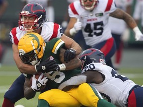 Montreal Alouettes' Christophe Normand and Jeshrun Antwi tackle Edmonton Elks' Terry Williams during second-half CFL action in Edmonton, Alta., on Saturday, Aug. 14, 2021.