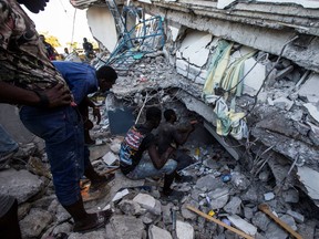 People look for survivors at a house destroyed following a 7.2 magnitude earthquake in Les Cayes, Haiti August 14, 2021. REUTERS/Ralph Tedy Erol NO RESALES. NO ARCHIVES