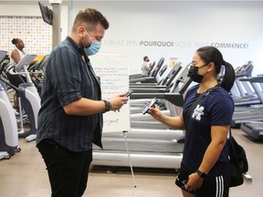 A patron has their vaccine passport scanned at an  Econofitness gym in Laval, Quebec, Canada August 17, 2021.